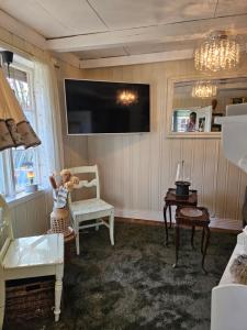 a living room with a tv on the wall at Hammergaarden Stabbursstua - Heritage Loft Stay in Sortland