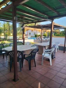 a patio with tables and chairs under a pergola at Monte dos Pintos in Arronches