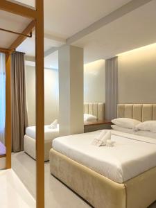 a bedroom with two beds and a mirror at Olive's Suites in Kalibo