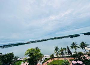 a view of a river with palm trees and a bridge at Century Riverside Hotel Hue in Hue