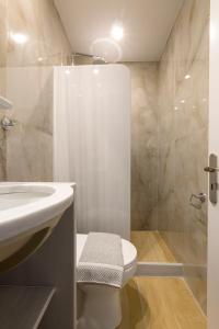 a bathroom with a toilet and a sink and a shower at Bay's in Spetses +90 photos