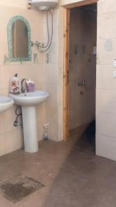 a bathroom with a sink and a shower with a mirror at SafeZone Guesthouse in Dahab