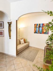 a living room with a couch and a painting on the wall at Domus REA Bracciano - Self Check-in H24 in Bracciano +31 photos