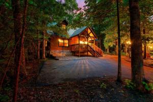 a large log cabin in the woods at night at Awesome Adventures By Avada Properties in Sevierville