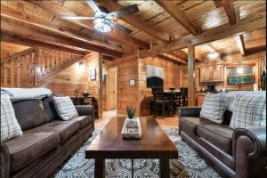 a living room with couches and a table in a cabin at Awesome Adventures By Avada Properties in Sevierville
