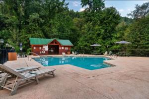 a swimming pool with a cabin in the background at Awesome Adventures By Avada Properties in Sevierville