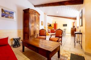 a living room with a wooden table and chairs at La Ferme D'estafinette in Redortiers