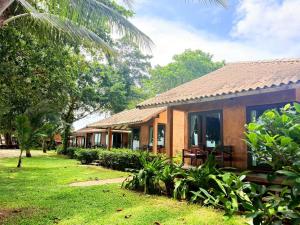 a house with a grassy yard in front of it at Flora I Talay in Ko Chang