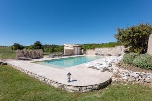 a swimming pool with two cars parked next to it at La Ferme D'estafinette in Redortiers
