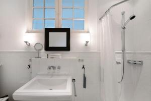 a bathroom with a sink and a mirror and a shower at Gut Rattelvitz, Parterre A OST in Gingst