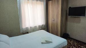 a bedroom with a bed with a towel on it at Sitora in Chirchiq