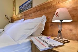 a bed with pillows and a lamp on top of it at Miramonti in Valtournenche