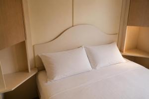 a bed with two white pillows in a room at Chalet Ardennen The Great Hill in Amblève