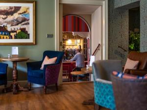 a man standing at a counter in a restaurant at Diglis House Hotel in Worcester