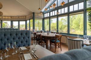 a restaurant with tables and chairs and windows at Diglis House Hotel in Worcester