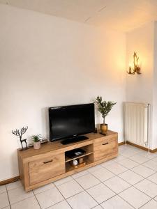 a flat screen tv sitting on top of a wooden entertainment center at Apartment Auszeit in Ulrichstein