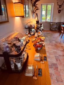 a table with food on it in a kitchen at Manoir de Daubeuf in Daubeuf-Serville