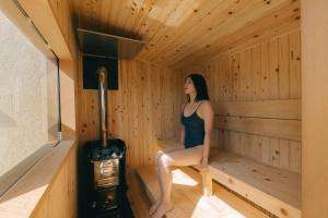 a woman is sitting in a sauna at semilla 名護 沖縄 in Nago