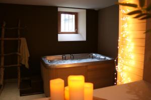 a bathroom with a tub with a window and lights at La Maison de Jeanne, maison d'hôtes in Thiézac +54 photos