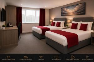 a hotel room with two beds with red pillows at Saram Lodge Dudley in Dudley