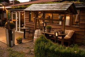 a gazebo with a bench and a table in a yard at Chalet Ardennen The Great Hill in Amblève