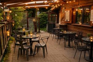 an outdoor patio with tables and chairs and lights at Chalet Ardennen The Great Hill in Amblève