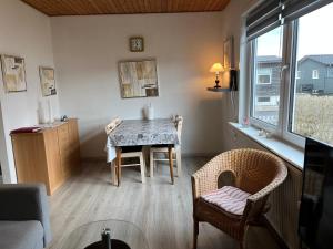 a living room with a table and chairs and a window at Cozy Apartment in Hirtshals in Hirtshals