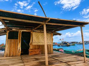 a small building on a dock with a boat at Cactos Floating House Experience on Island in Lai Sơn +22 photos