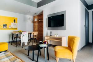 a living room with a tv and a table and chairs at PlanB Hotel - Living Chamonix in Chamonix