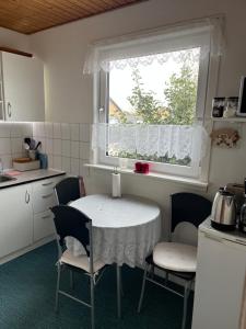 a kitchen with a table and chairs and a window at Cozy Apartment in Hirtshals in Hirtshals +4 photos