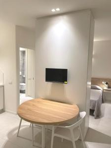 a room with a table and a tv on a wall at Appartamenti Angelo e Maria in Lovere