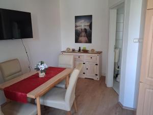 a dining room with a table and chairs and a television at NEU! See-Ferienwohnung 3 in Großmöhlau