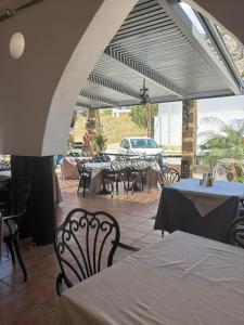 a patio with tables and chairs and a car parked at Coralli Beachfront in Pefki