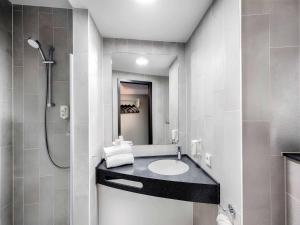 a bathroom with a sink and a shower at B&B HOTEL Memmingen in Memmingen