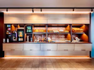 a fast food restaurant with a counter with food at B&B HOTEL Memmingen in Memmingen