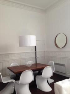 uma sala de jantar com uma mesa e cadeiras brancas em Appartement Maison Aubanel em Avignon