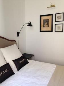 um quarto com uma cama com um candeeiro e fotografias na parede em Appartement Maison Aubanel em Avignon