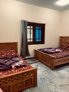 a bedroom with two beds and a window at Rayn Basayra Kashmir in Bāta