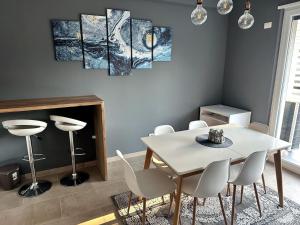 a dining room with a white table and chairs at White Sand Apartment Valamar 2 Bedroom Balcony Parking in Draç +14 photos