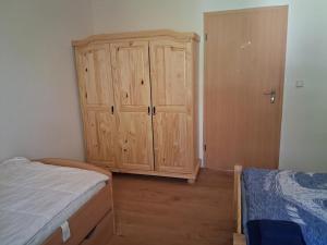 a bedroom with a wooden cabinet and a bed at NEU! See-Ferienwohnung 4 in Großmöhlau