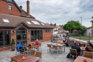 a group of people sitting at tables on a patio at The Wellington in Bristol