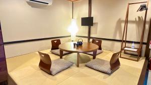 a room with a table and chairs and a lamp at Kyoto Gion No Yado in Kyoto
