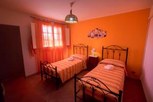 two beds in a room with orange walls at Villa Laura Salento in Marina di Pescoluse