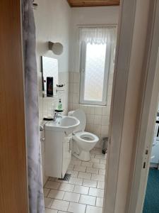 a white bathroom with a toilet and a sink at Cozy Apartment in Hirtshals in Hirtshals