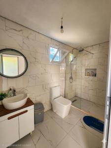 a bathroom with a toilet and a sink and a shower at Vila zaho in Dhërmi