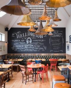 uma sala de jantar com mesas e cadeiras e um quadro-negro em The Wellington em Bristol