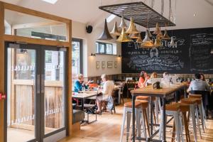 un grupo de personas sentadas en mesas en un restaurante en The Wellington, en Bristol 32 fotos más