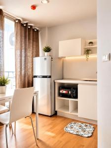 a kitchen with a white refrigerator and a table at Condo Tulip Square at Aomnoi in Ban Khlong Om Noi