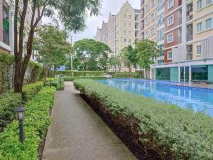 a walkway through a park with tall buildings at Condo Tulip Square at Aomnoi in Ban Khlong Om Noi
