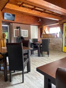 a dining room with tables and chairs and a fireplace at Motel “La Butuci” in Timisul de Jos